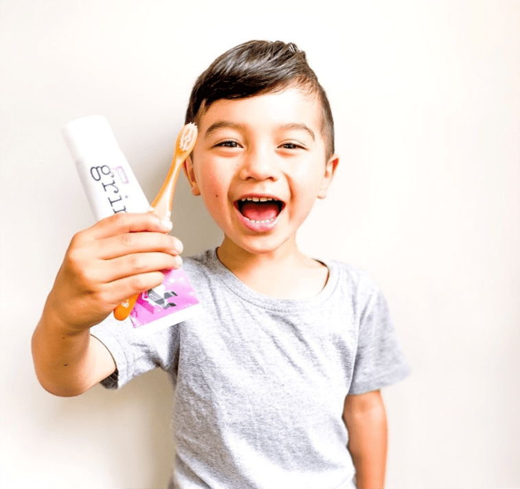 Little Boy Holding Grin Toothpaste & Toothbrush